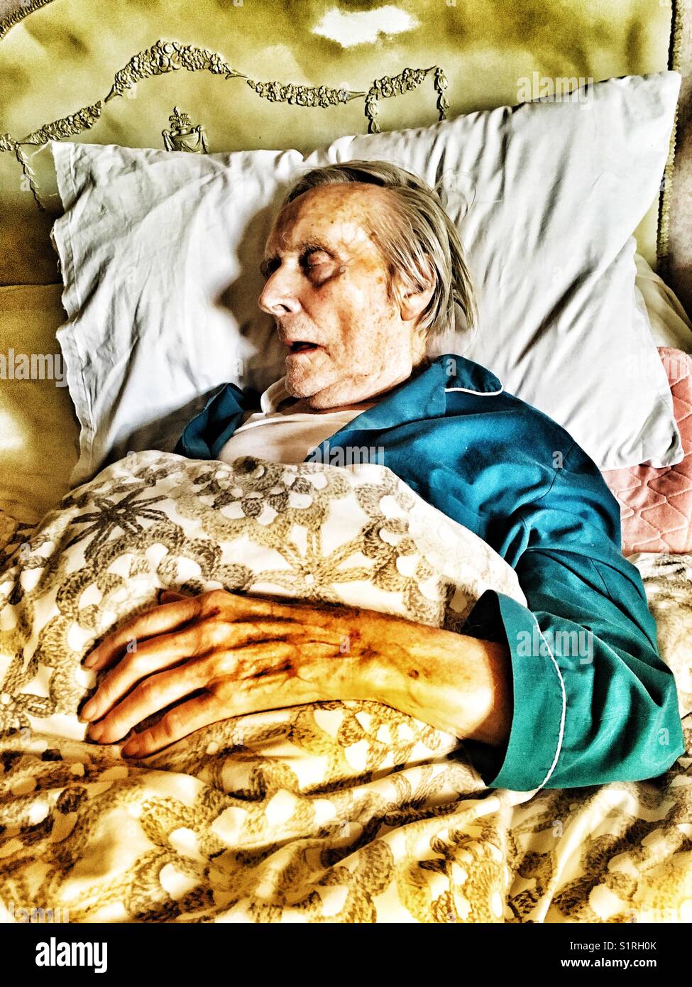 Elderly man asleep in bed Stock Photo