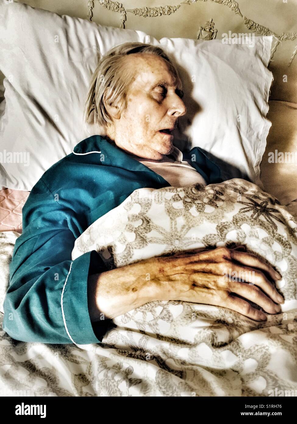 Unwell elderly man sleeping in bed - Smartphone Captured Stock Image