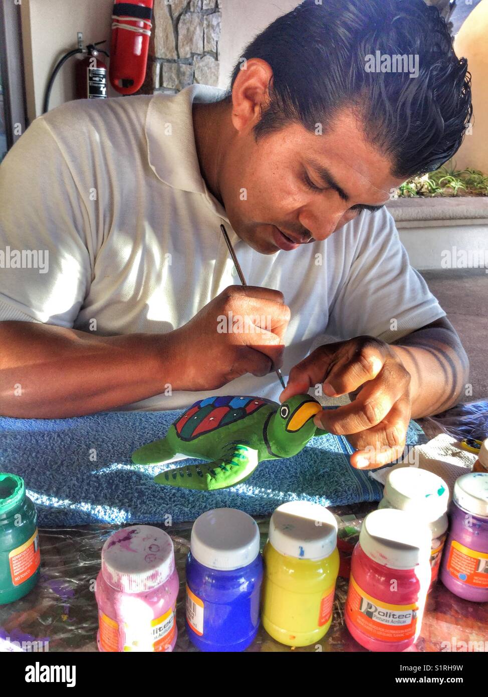 An artisan painting a clay turtle. - Smartphone Captured Stock Image