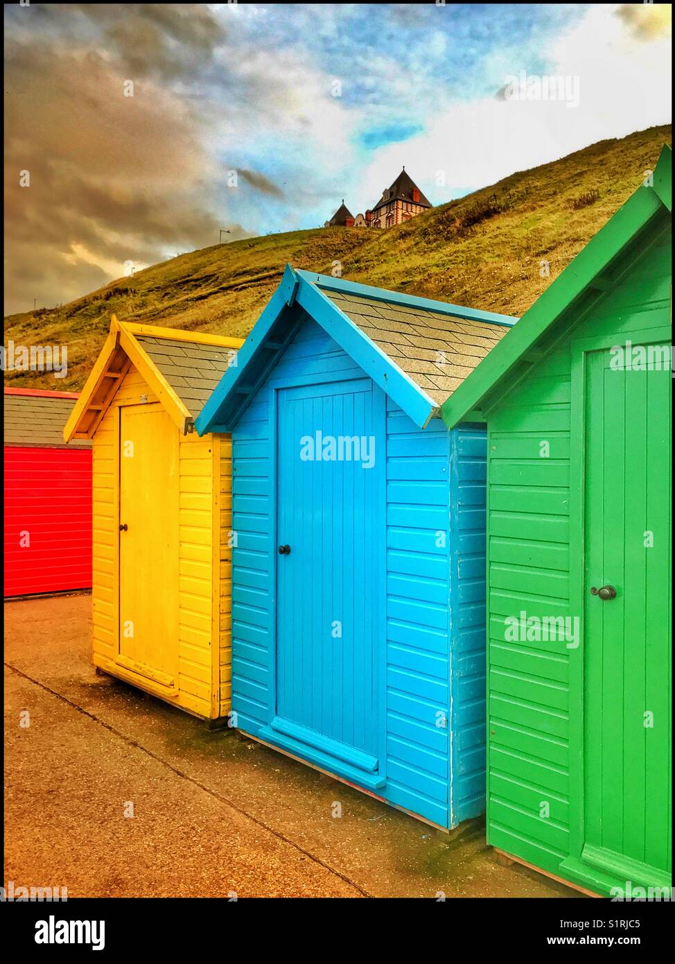 Brightly coloured Beach Huts near the seaside at Whitby, Yorkshire, England. It is nearing sunset, so people have returned to their accommodation. Photo Credit - © COLIN HOSKINS. - Smartphone Captured Stock Image