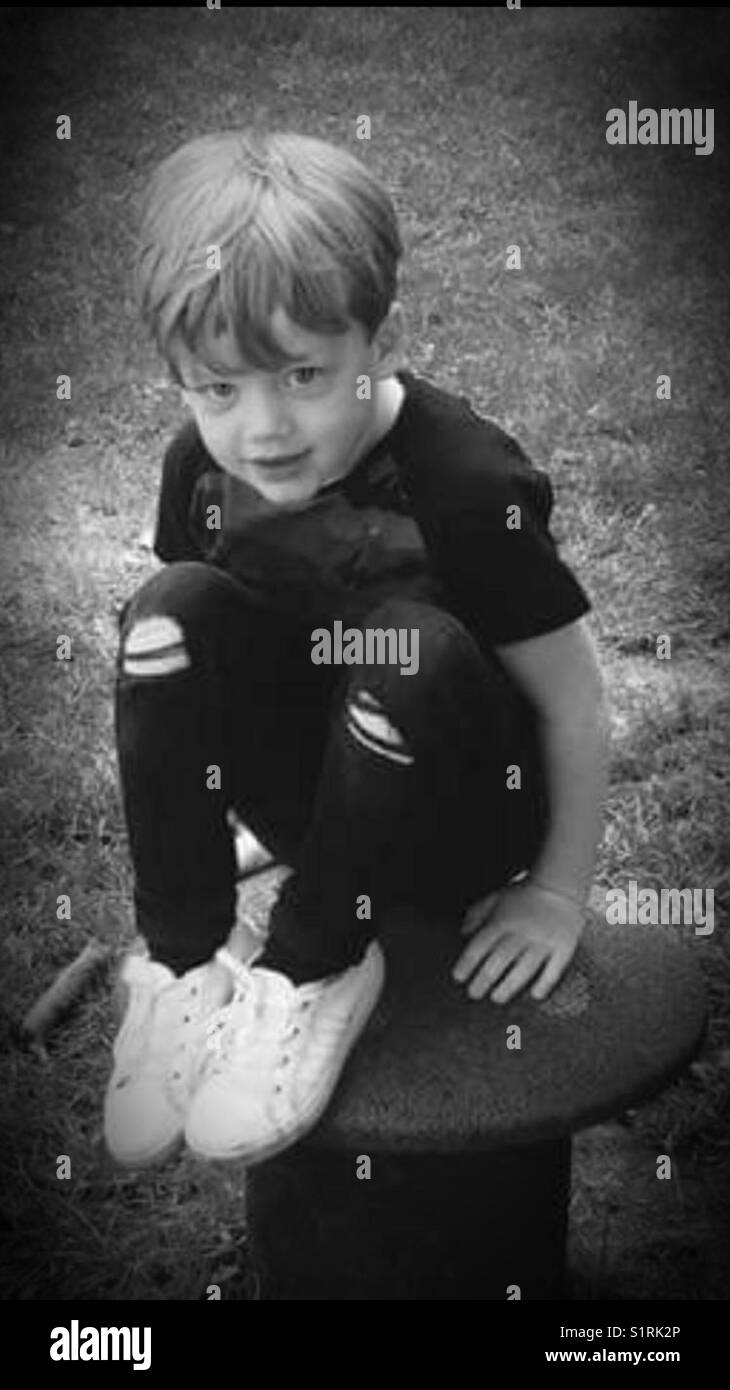 Boy sitting on a toad stool. Stock Photo