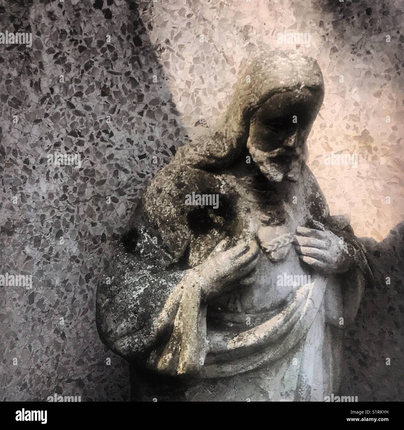 An sculpture of the Sacred Heart of Jesus decorates a tomb during Day of the Dead in Mexico City, Mexico. - Smartphone Captured Stock Image