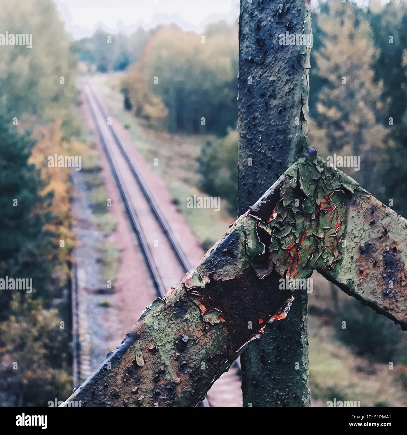Train tracks towards Chernobyl power plant, framed by rusting and peeling metal railings - Smartphone Captured Stock Image