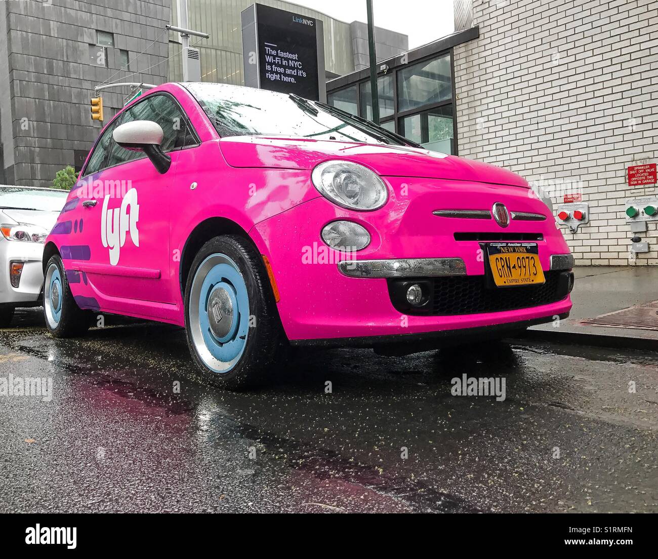 Fiat 500 painted pink and carrying a Lyft logo is parked in the streets of Manhattan. Stock Photo