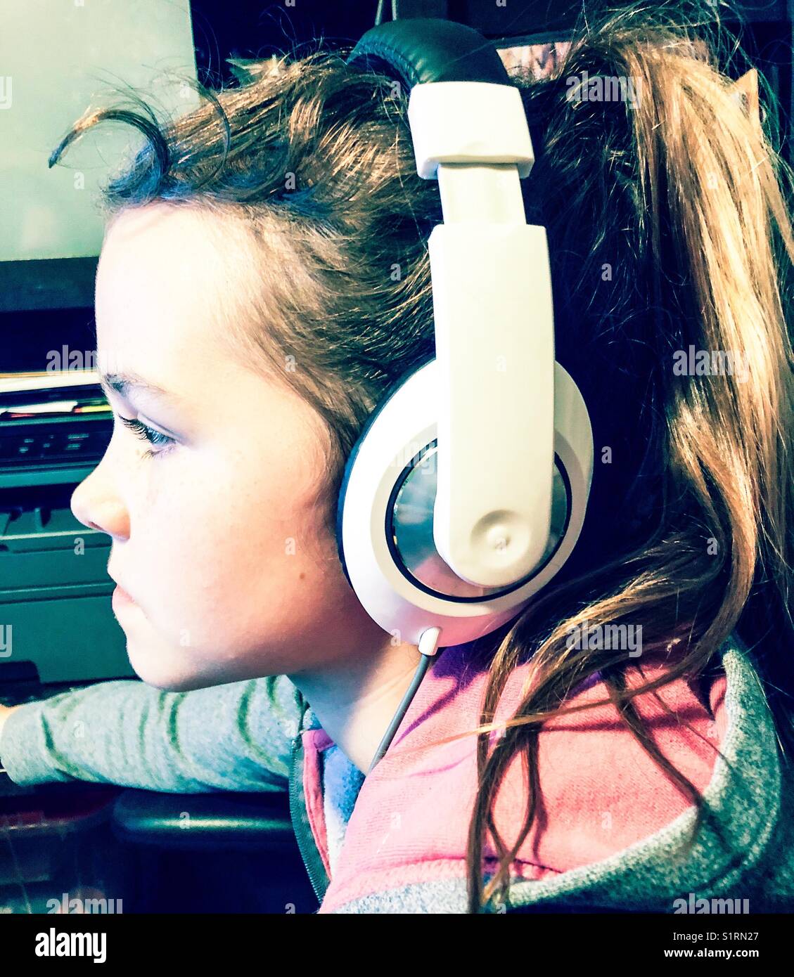 Profile view of girl wearing large white headphones - Smartphone Captured Stock Image
