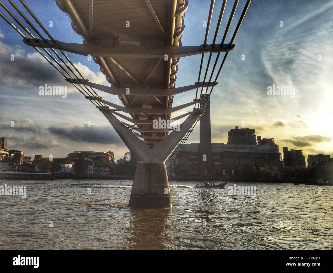 A boat passes under Millennium Bridge in London, England. Photo take on November 3 2017 - Smartphone Captured Stock Image