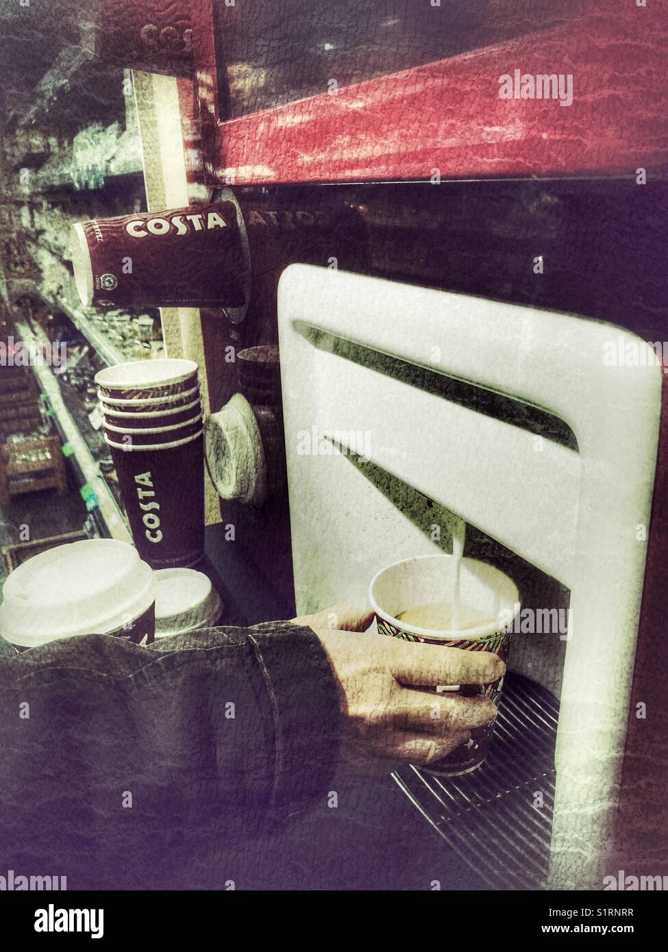 Woman using a Costa self service coffee machine in a supermarket on a university campus, UK. - Smartphone Captured Stock Image