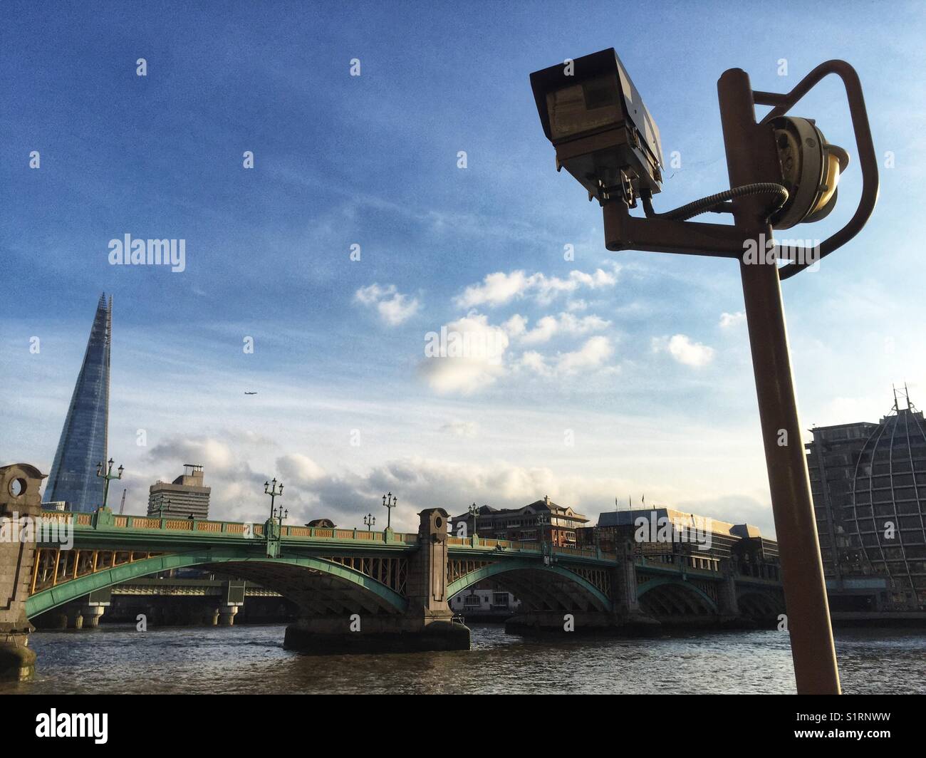 CCTV cameras on the river Thames, Southwark Bridge and the Shard seen in the distance in London, England. Photo taken on November 3 2017 - Smartphone Captured Stock Image