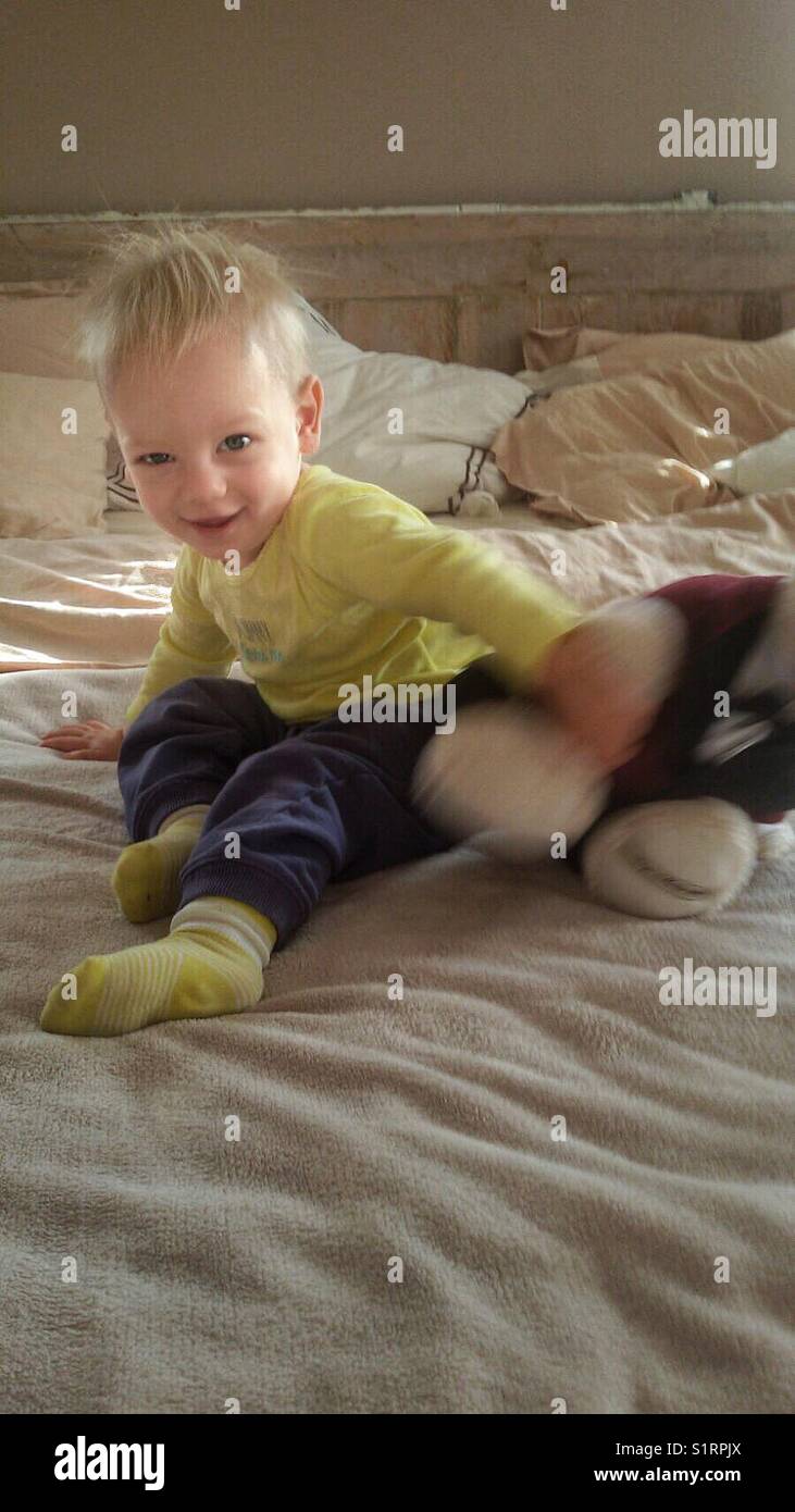 Baby boy playing with teddy bear Stock Photo - Alamy