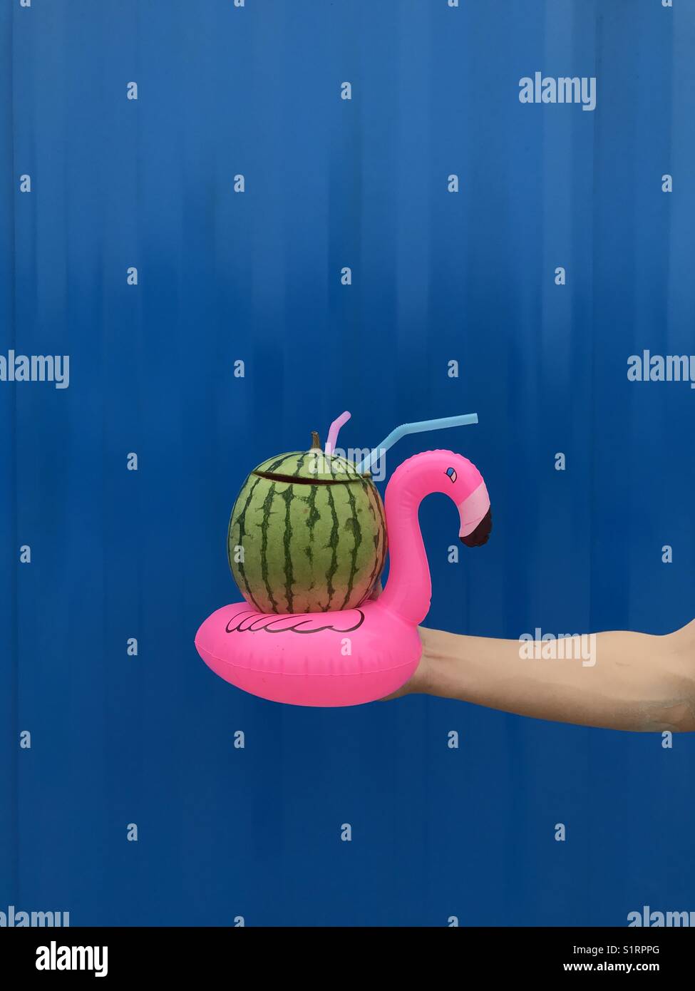 Watermelon juice drink in an inflatable flamingo cup holder Stock Photo