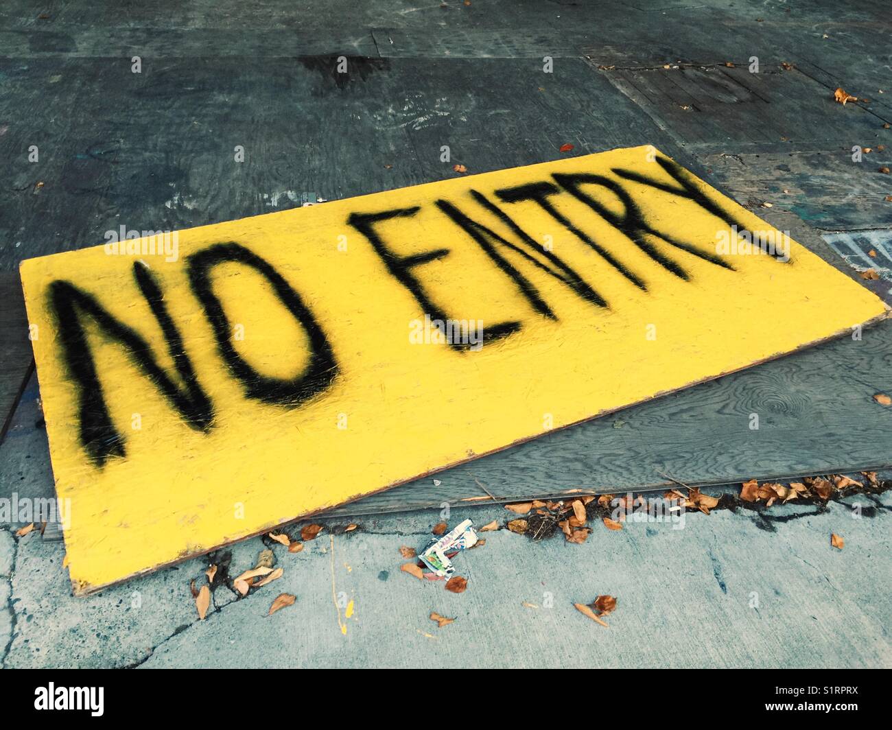 No Entry Sign Spray Painted On Large Yellow Sheet Of Plywood