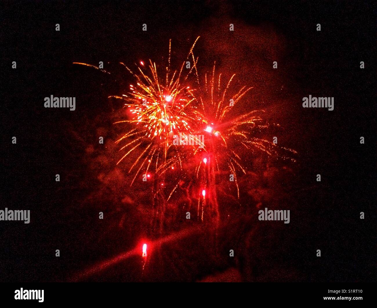 Red fireworks explosion, Hampshire, England, United Kingdom. - Smartphone Captured Stock Image