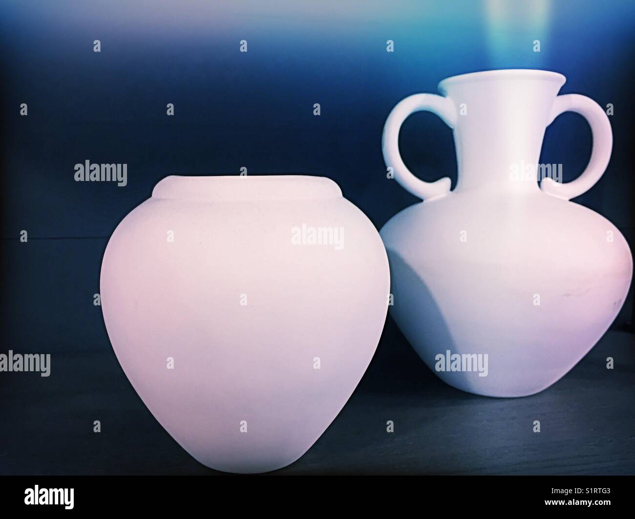 Two white vases on dark blue background Stock Photo