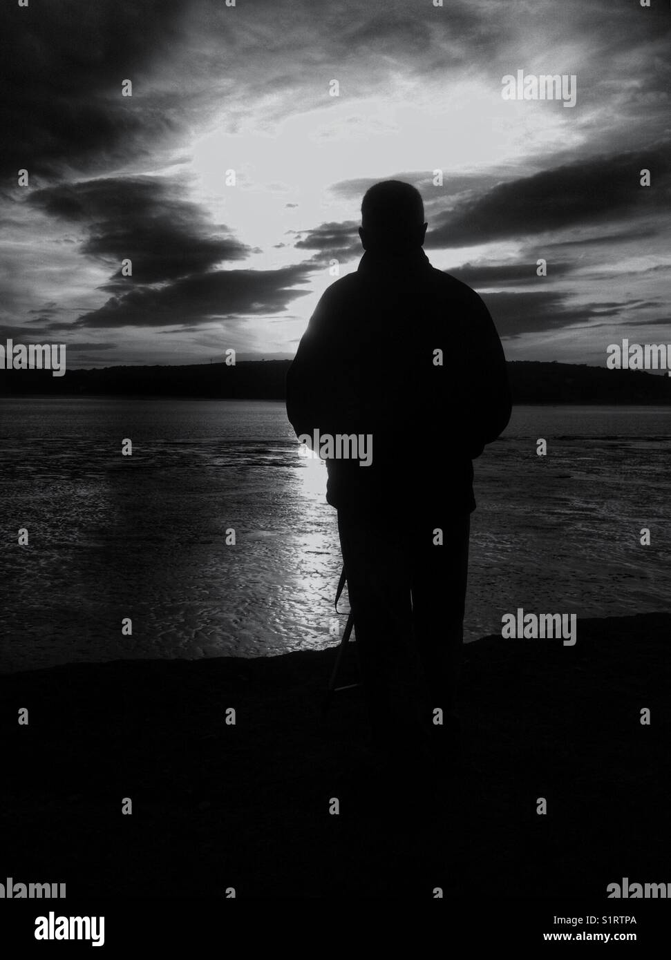 Man gazing at the sunset. Black and white. Stock Photo