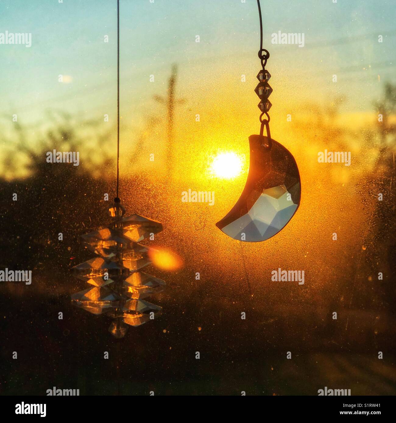 Crystals hanging in a window with the morning sunrise behind - Smartphone Captured Stock Image
