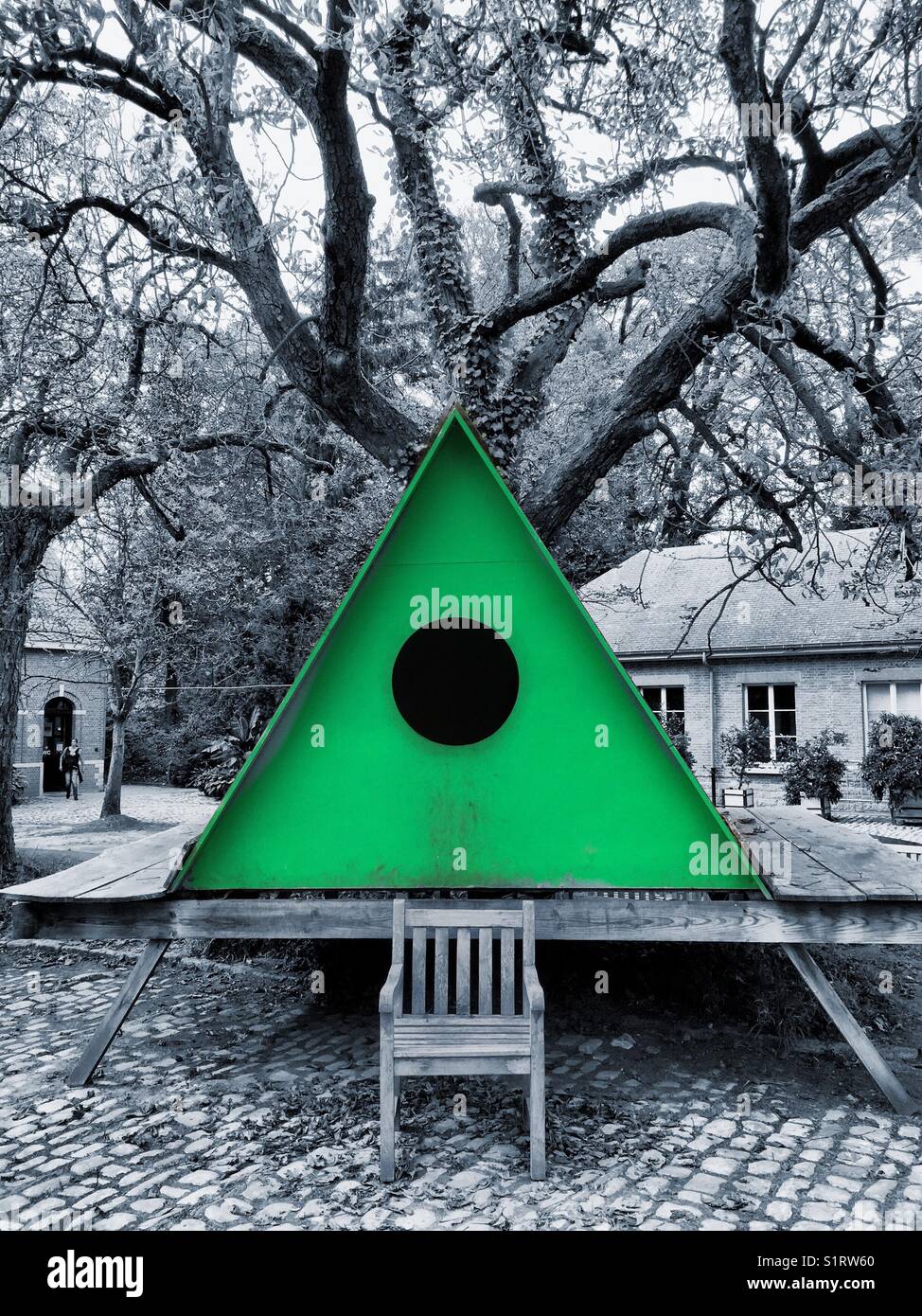 Green triangle cabin in front of a tree - Smartphone Captured Stock Image