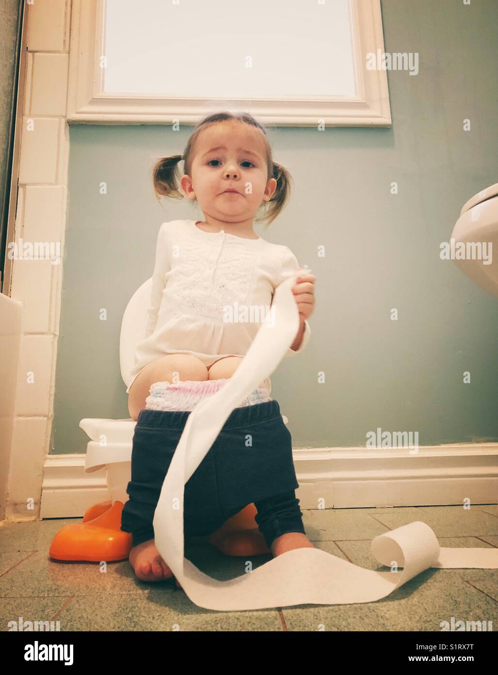 Potty training girl sitting on potty with funny expression Stock Photo -  Alamy