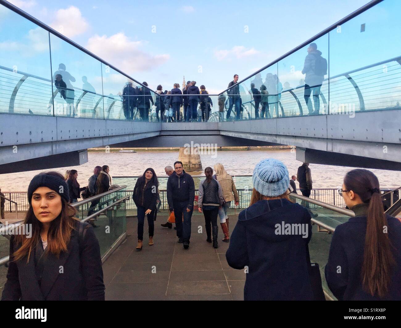 People walking over Millennium Bridge, designed by Norman Foster. St Paul's Cathedral is seen in the distance. Photo taken on November 3 2017 - Smartphone Captured Stock Image