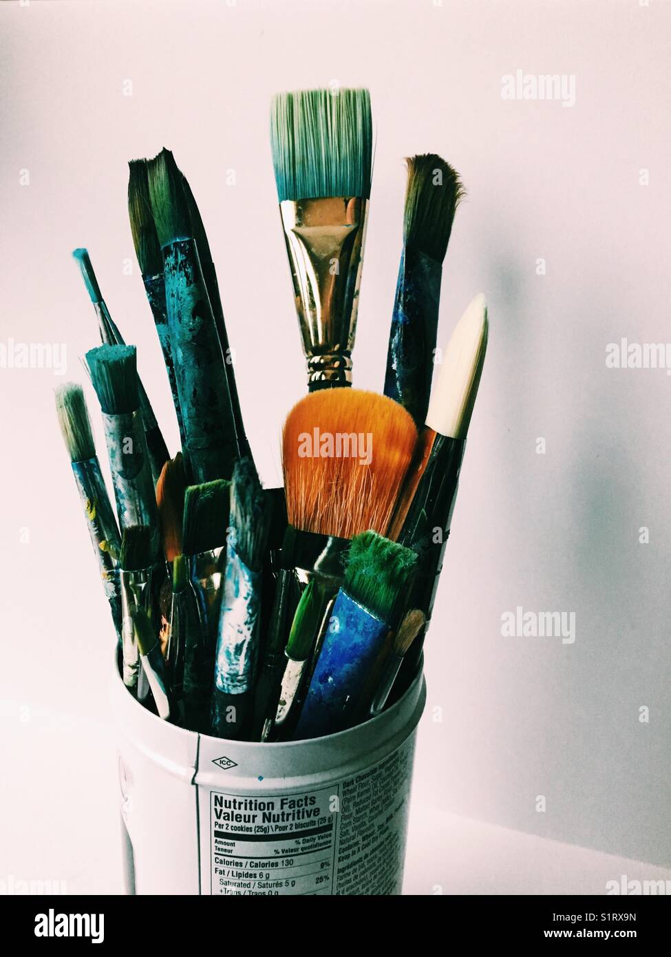 An assortment of fine art paintbrushes in a tin can with white background. - Smartphone Captured Stock Image