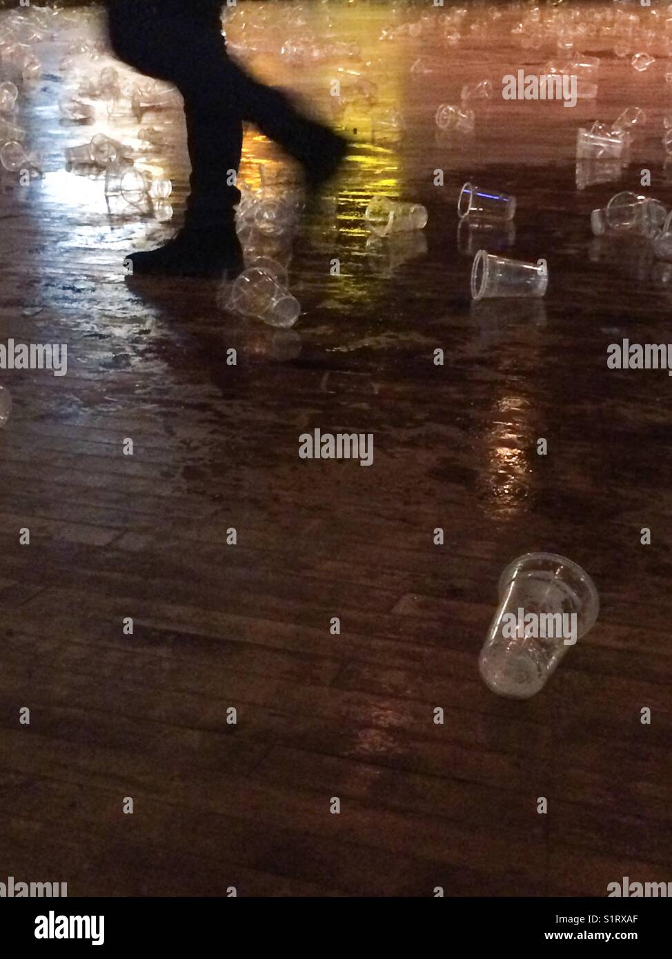 Empty plastic beer glasses and spilt beer on floor at the end of a concert Stock Photo
