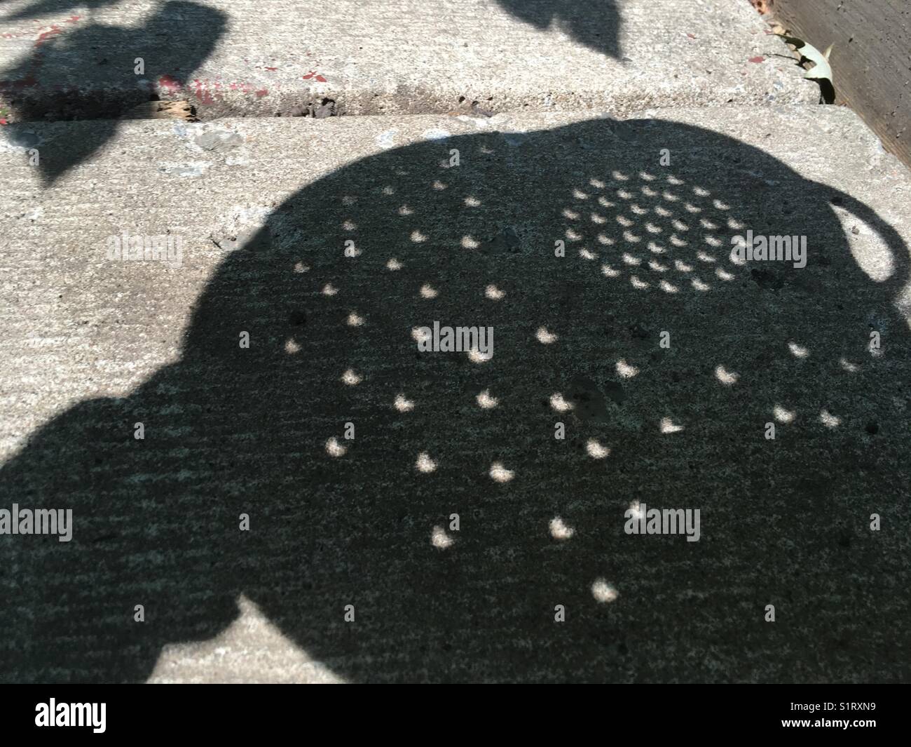 Eclipse shadow through colander Stock Photo Alamy