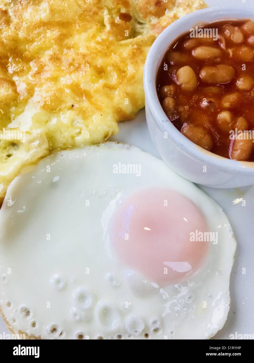 Breakfast with omelette, fried egg and baked beans Stock Photo Alamy
