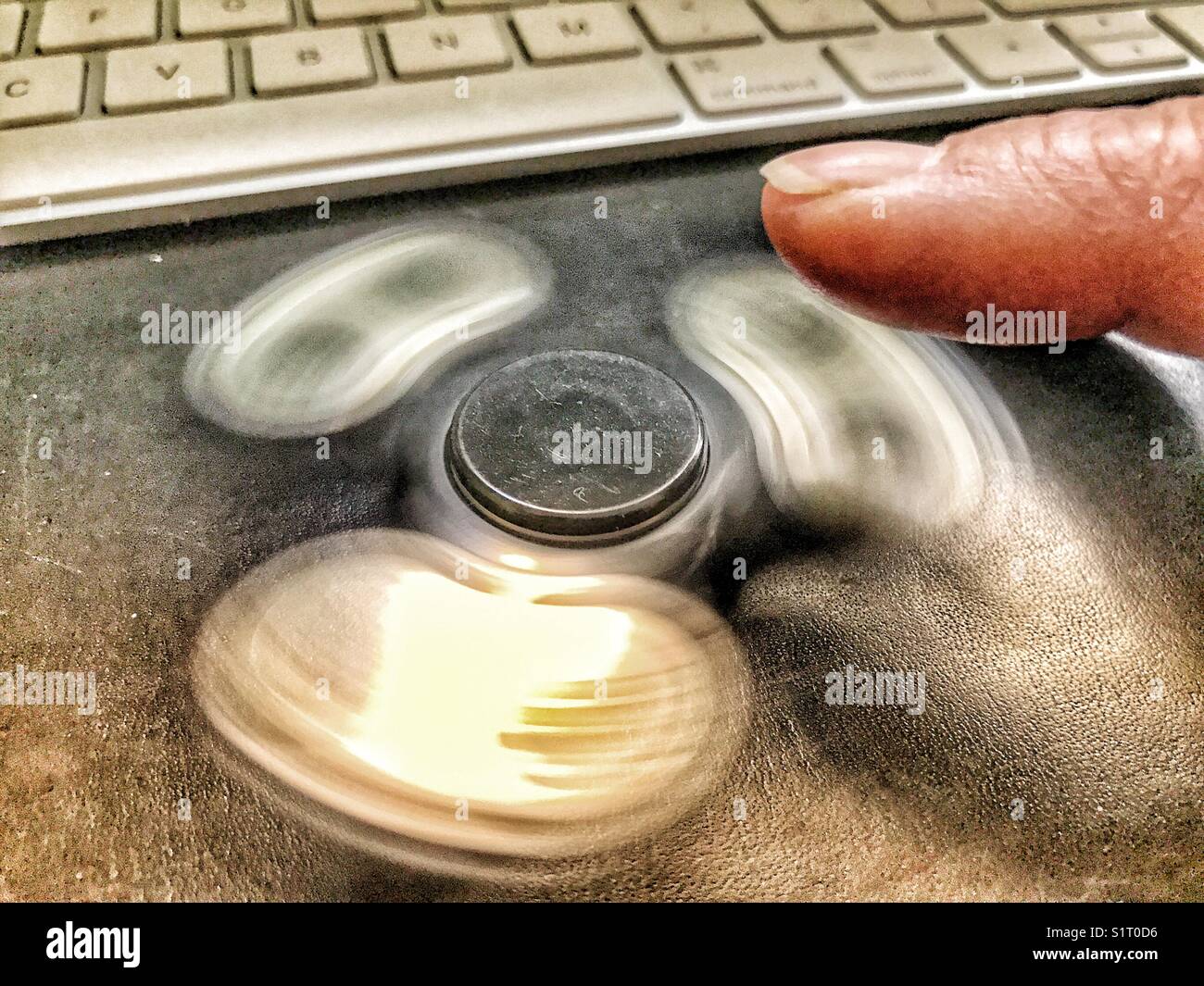 Finger, fidget spinner, computer keyboard - Smartphone Captured Stock Image