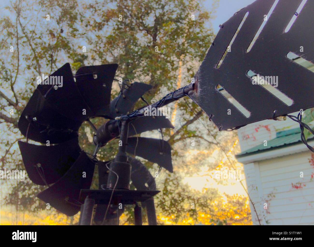 Windmill and low evening sun by old farmhouse - Smartphone Captured Stock Image