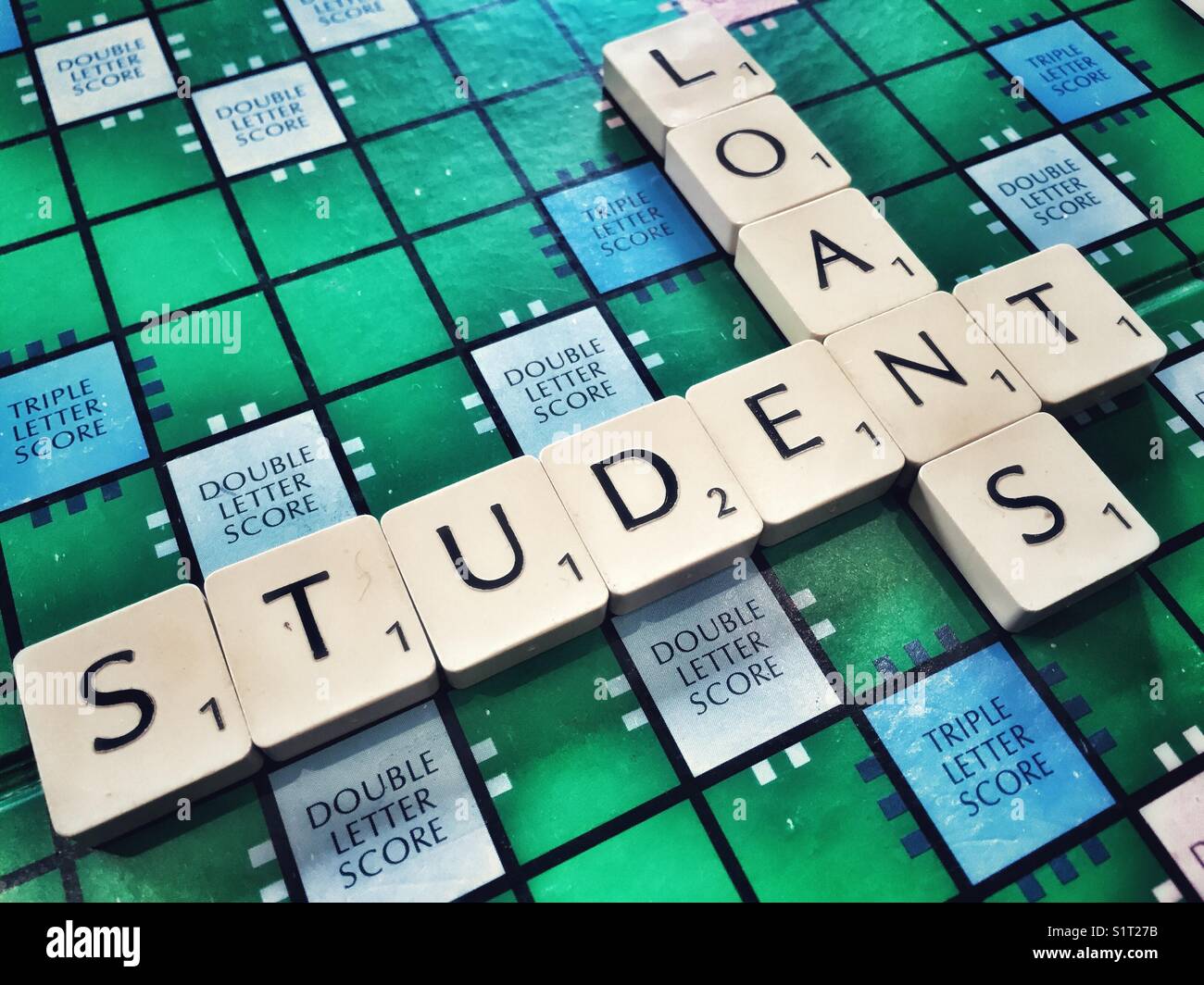 The words Student and Loans written on the board game Scrabble - Smartphone Captured Stock Image