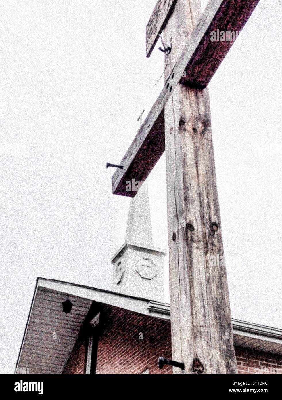 Pale photo of rustic cross and church steeple - Smartphone Captured Stock Image