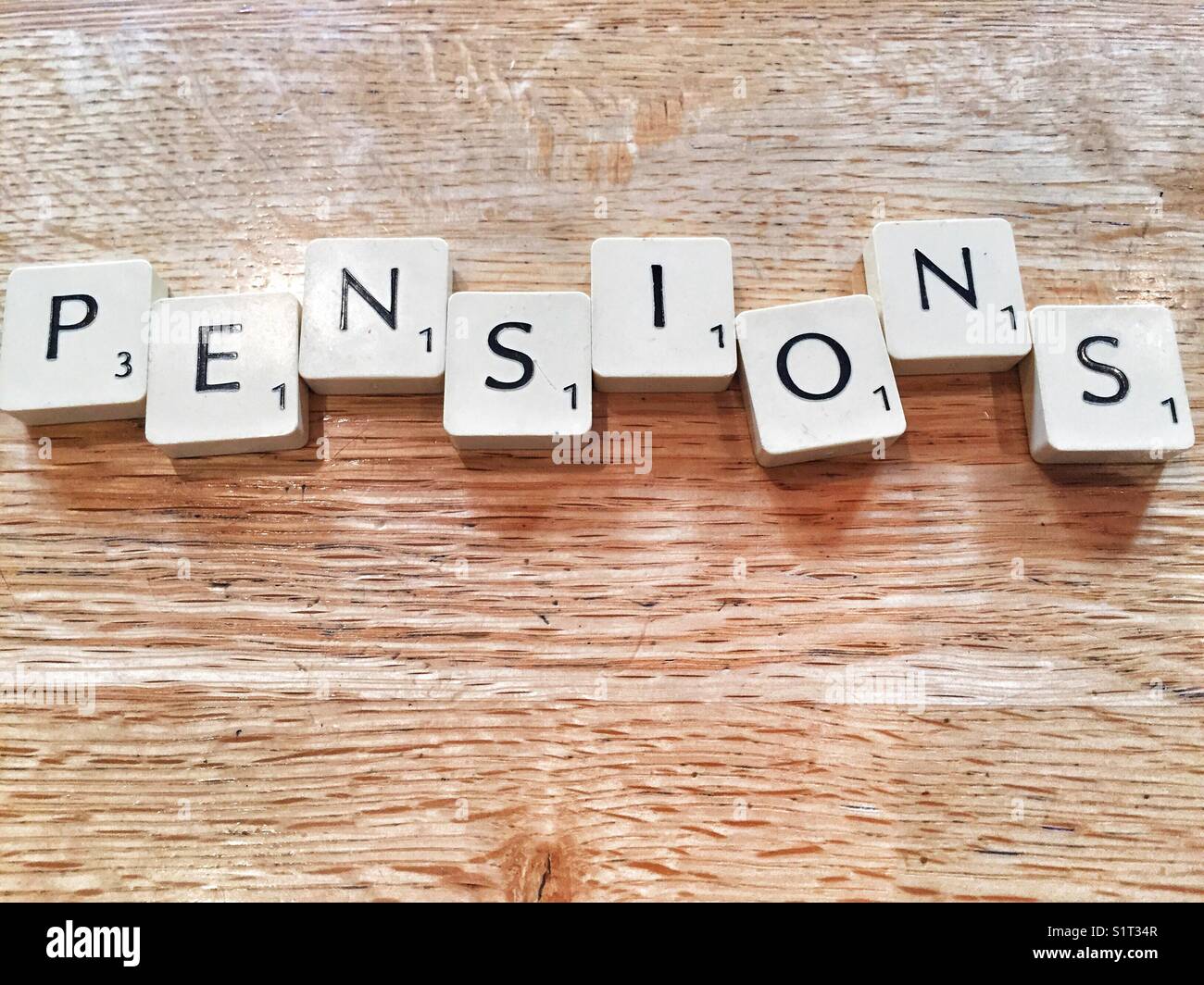 The word pensions written with scrabble tiles Stock Photo