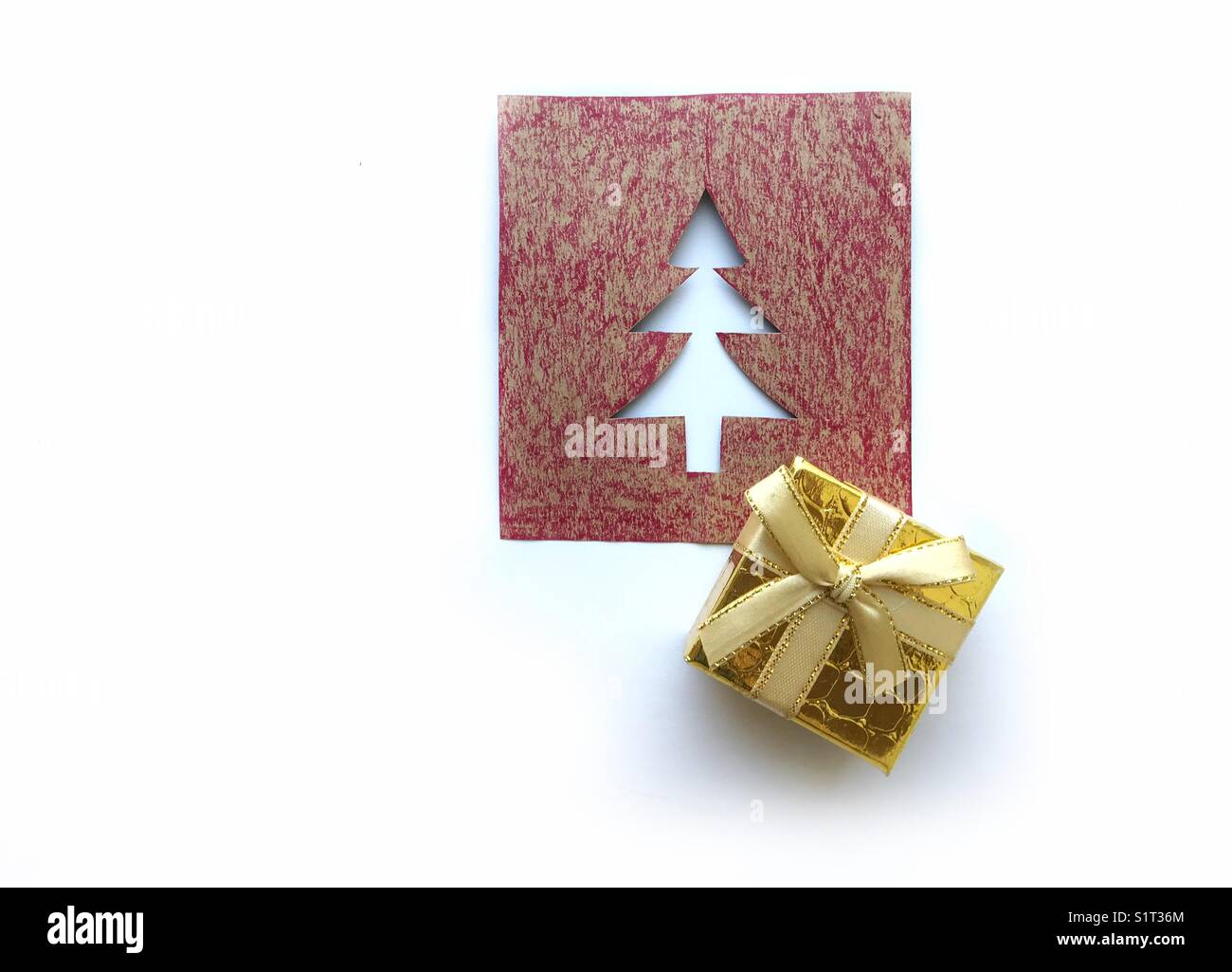 Christmas card with a golden gift box on it isolated in white background - Smartphone Captured Stock Image
