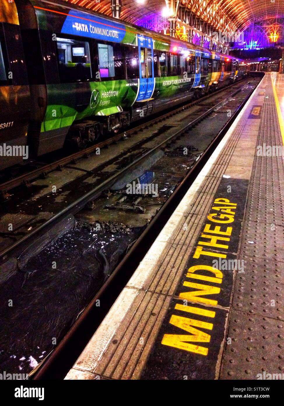 A Heathrow Express train at the platform in Paddington Railway Station at night. - Smartphone Captured Stock Image