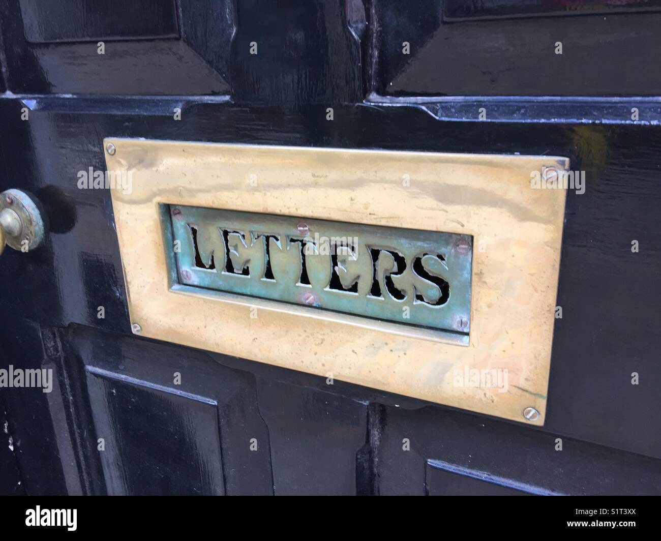 Beautiful brass letter box on blue door, fret Work lettering Stock Photo