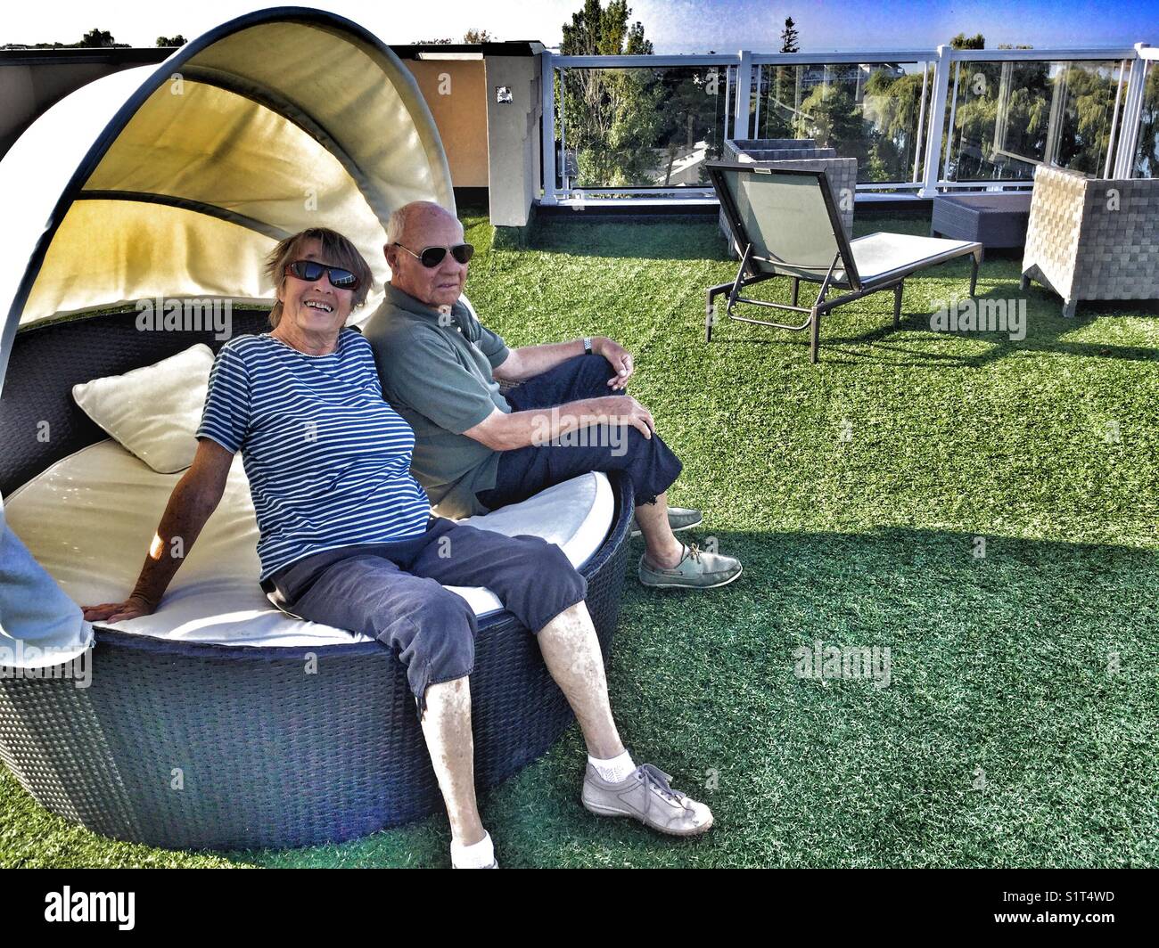 Elderly couple relaxing on a rooftop terrace. - Smartphone Captured Stock Image