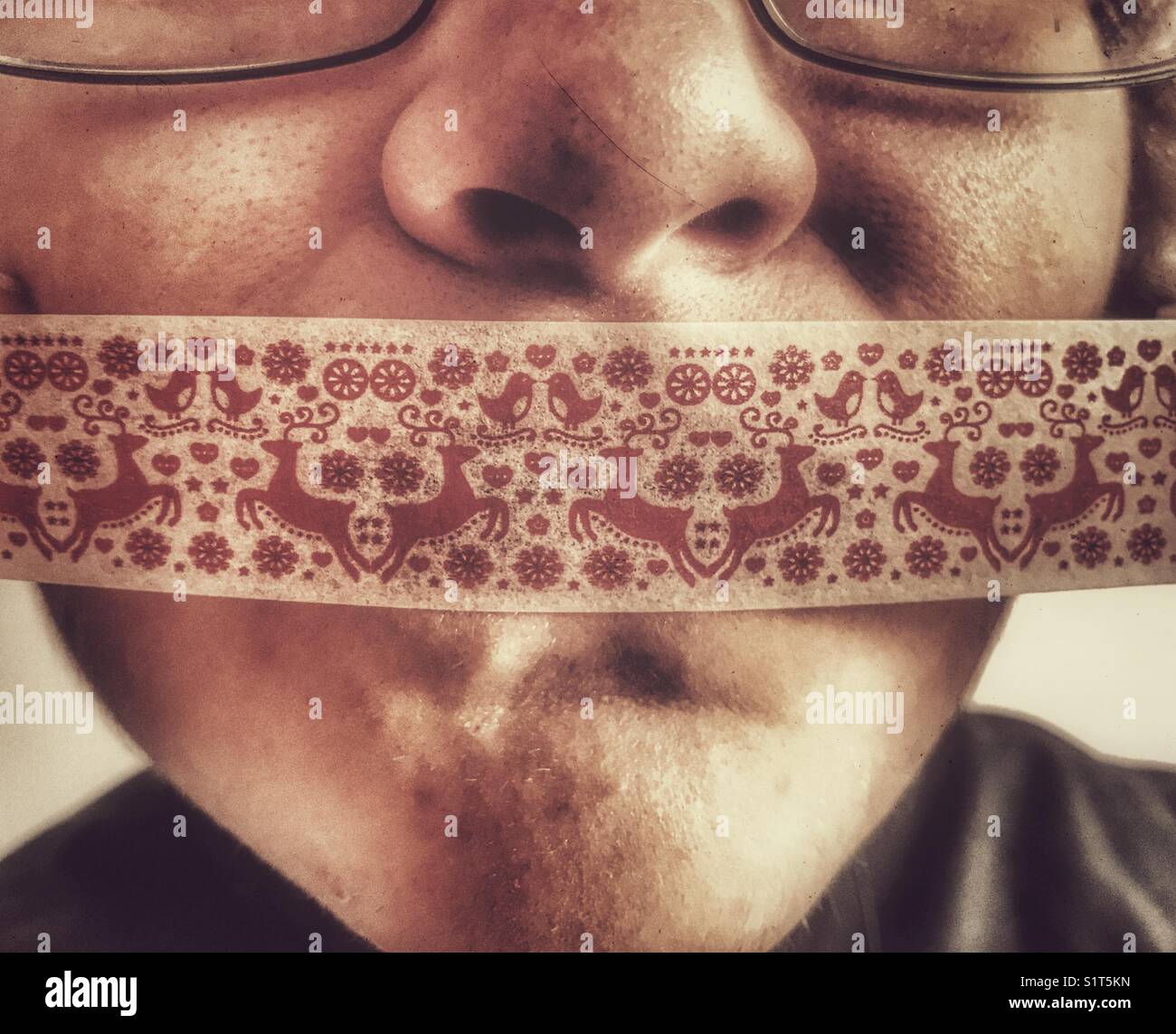 Young woman’s face with Christmas gift tape over her mouth - Smartphone Captured Stock Image