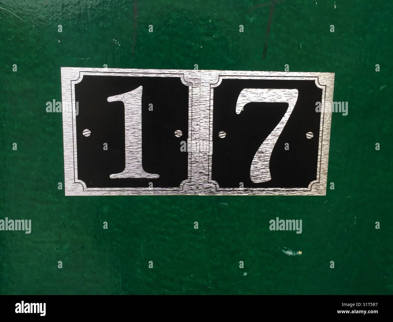 The number 17 on a green door - Smartphone Captured Stock Image