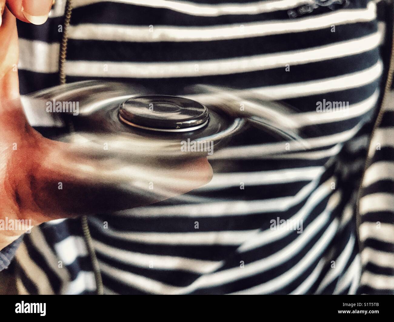 Fidget spinner, spinning on a hand - Smartphone Captured Stock Image