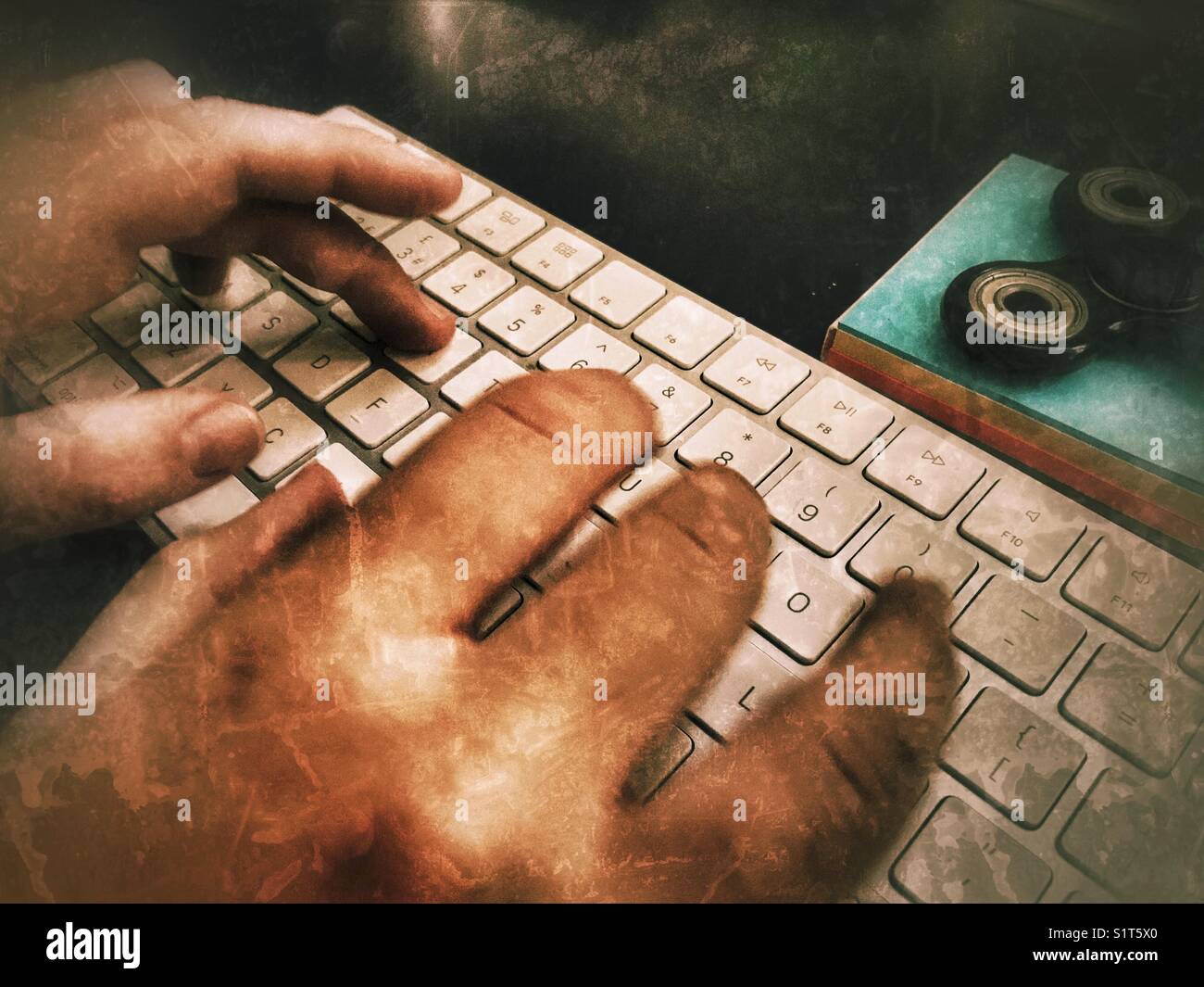 POV personal perspective, Millennial woman’s hands on computer keyboard with a fidget spinner on a blue notepad. - Smartphone Captured Stock Image