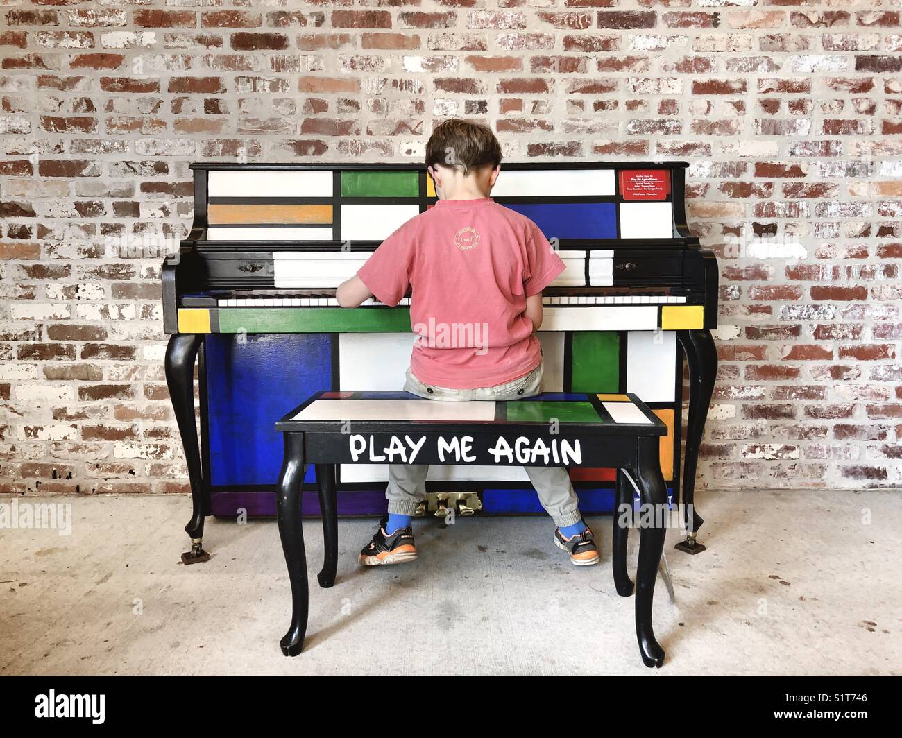Boy playing on a public piano on the Atlanta belt line Stock Photo