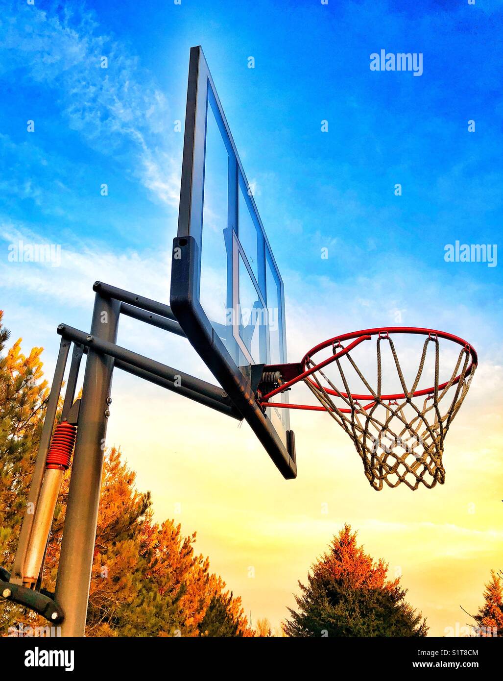 Colourful image of outdoor basketball net with bright morning light and blue sky - Smartphone Captured Stock Image
