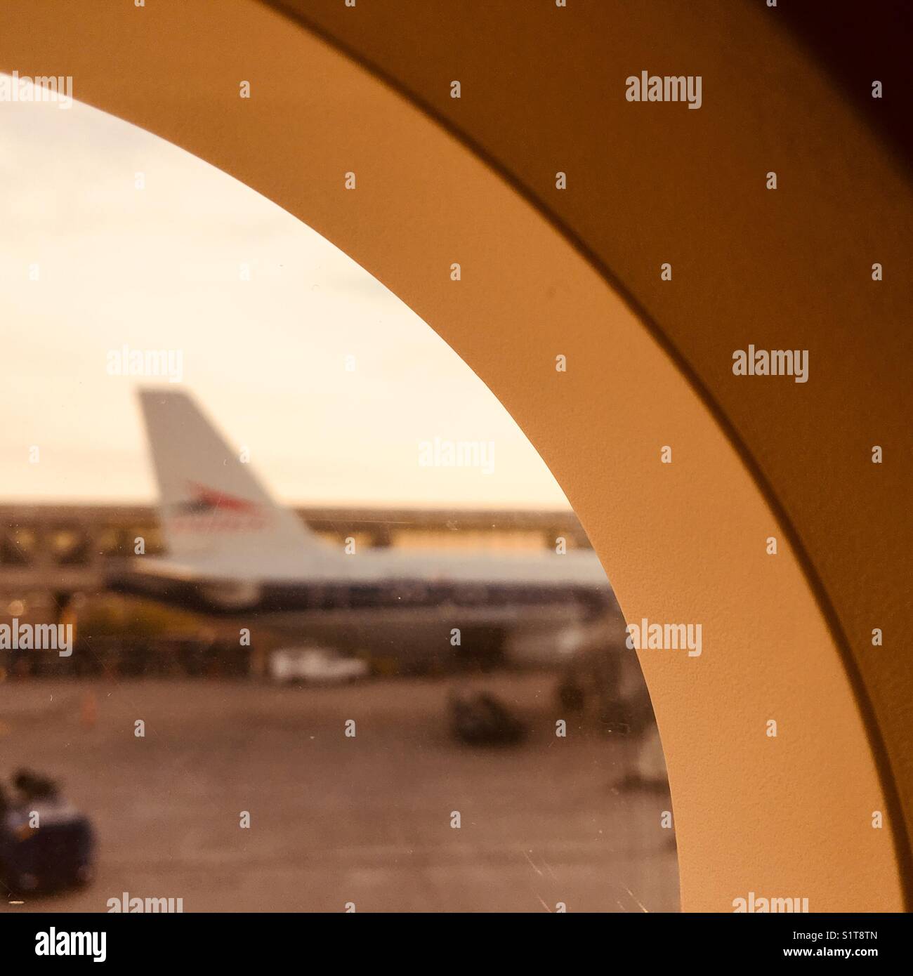 View from airplane window at airport at sunset. No identifying features visible - Smartphone Captured Stock Image