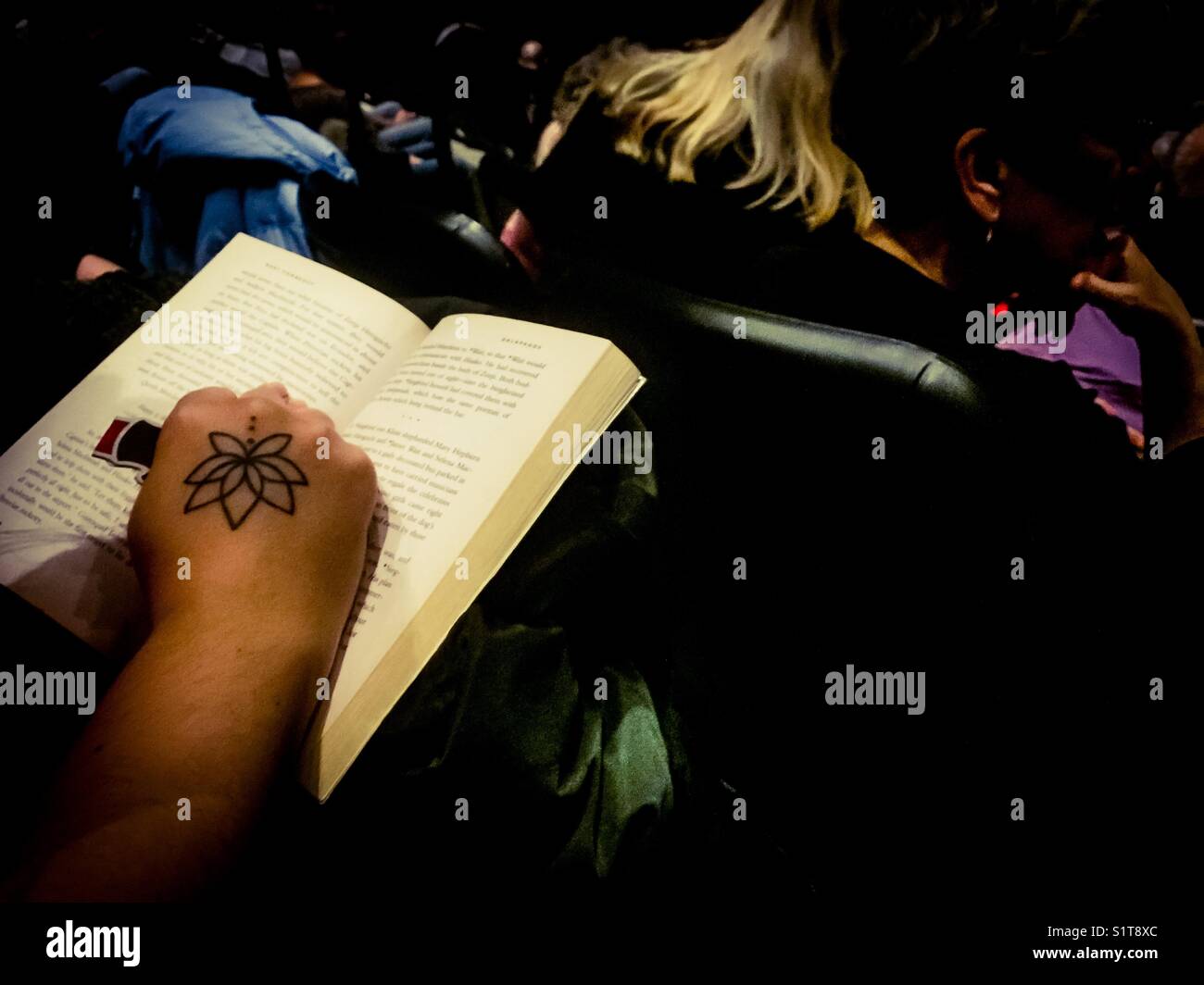 Reader with a flower tattoo - Smartphone Captured Stock Image