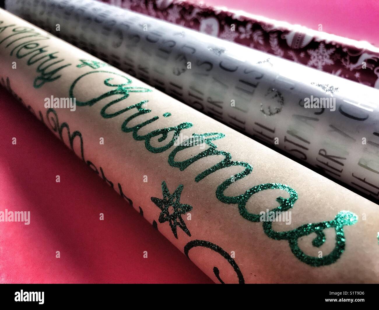 Three rolls of festive Christmas wrapping paper. - Smartphone Captured Stock Image