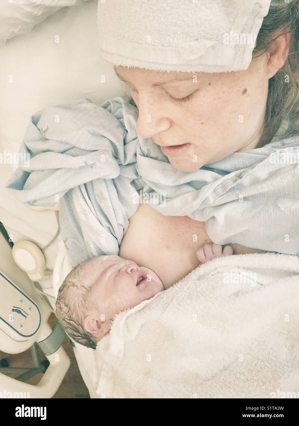 Real image of new mother with just born newborn on chest immediately after giving birth Stock Photo