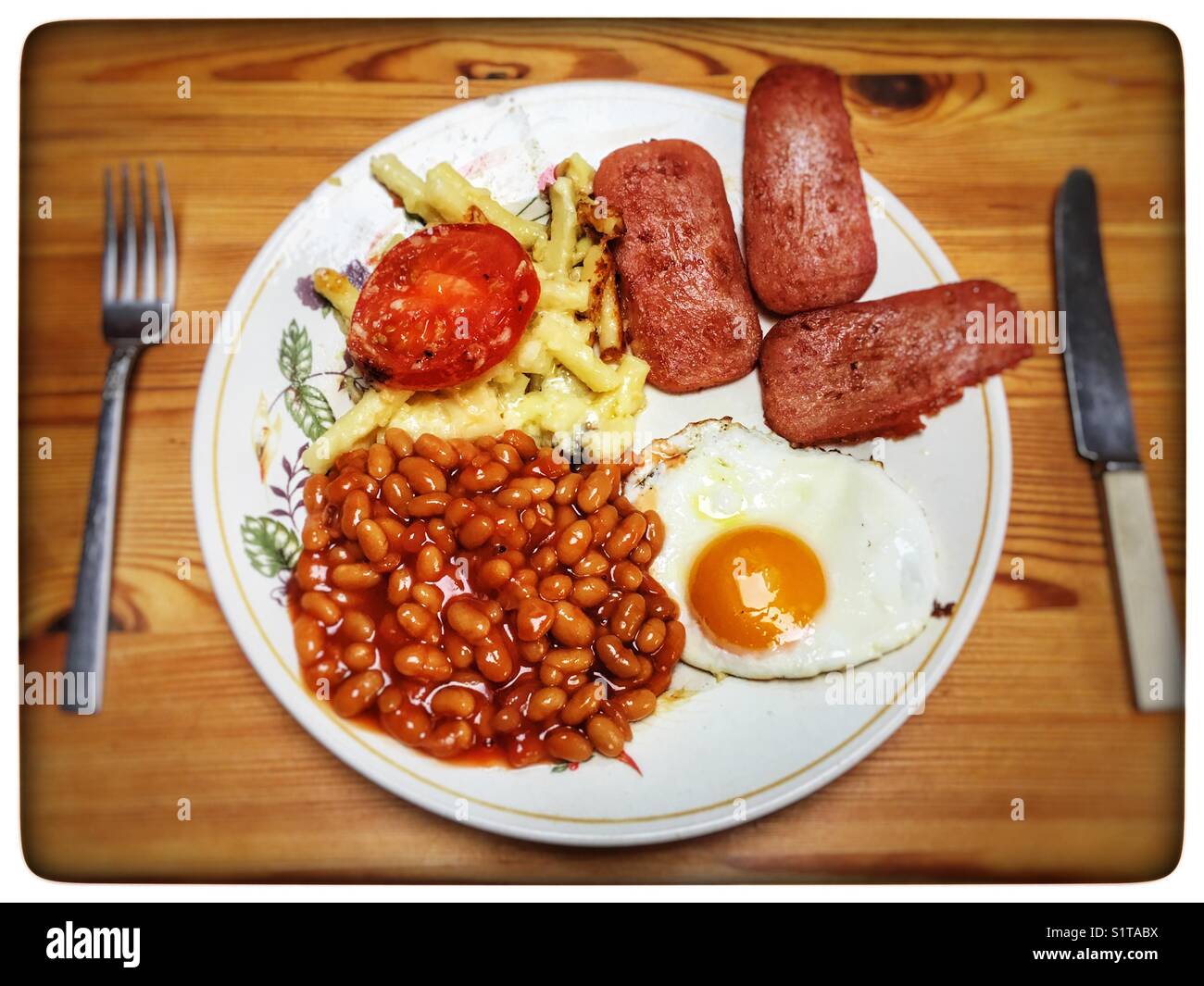 Spam fritters fried egg baked beans and macaroni cheese hires stock