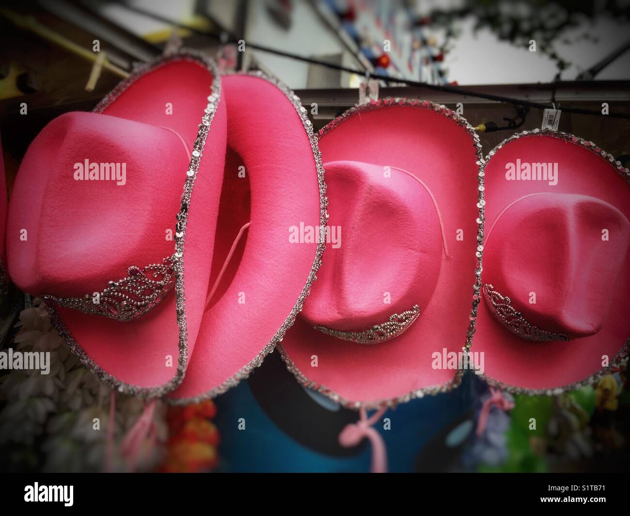Pink cowgirl hats hanging at street carnival Stock Photo