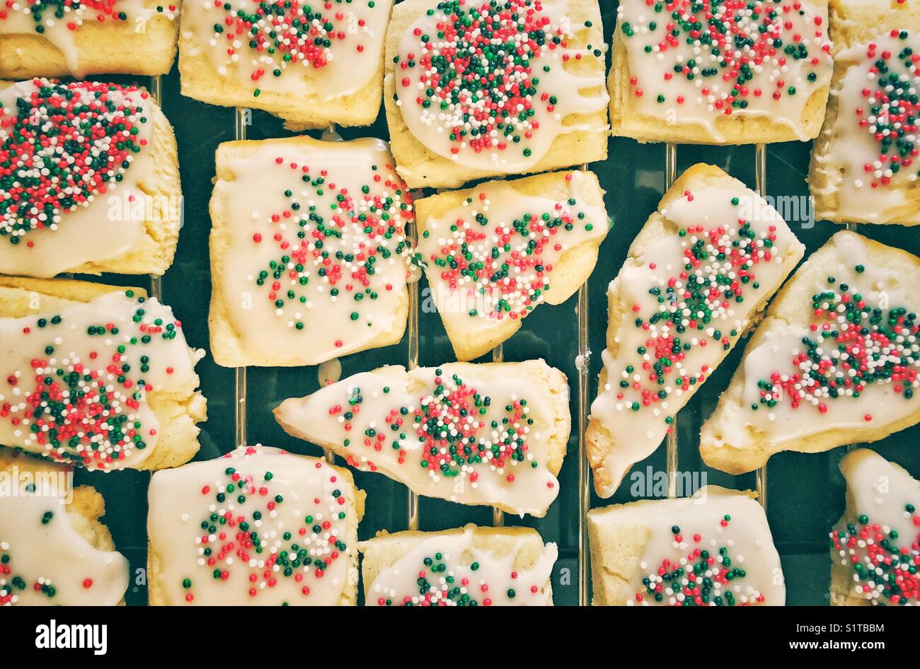 Homemade sugar cookies glazed with Christmas coloured sprinkles made by a child - Smartphone Captured Stock Image