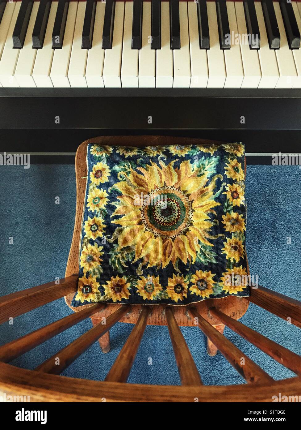 Keyboard and spindle backed chair with a sunflower tapestry cushion, high angle view. - Smartphone Captured Stock Image
