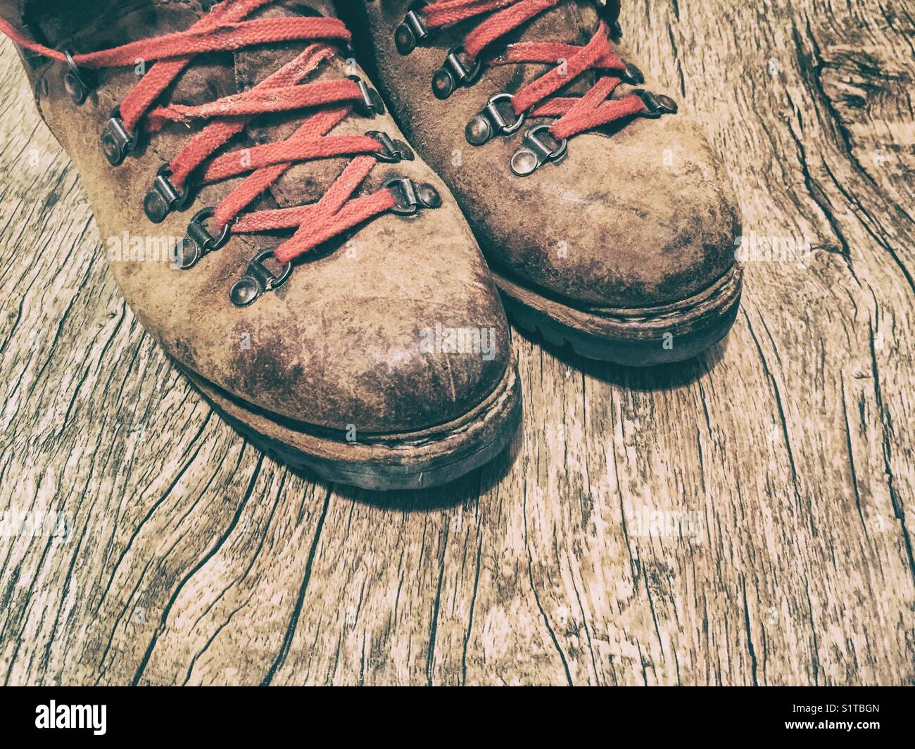 A pair of old hiking boots with red laces Stock Photo - Alamy